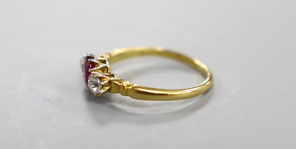 A yellow metal, single stone ruby and two stone diamond set ring, size N, gross weight 2.7 grams.